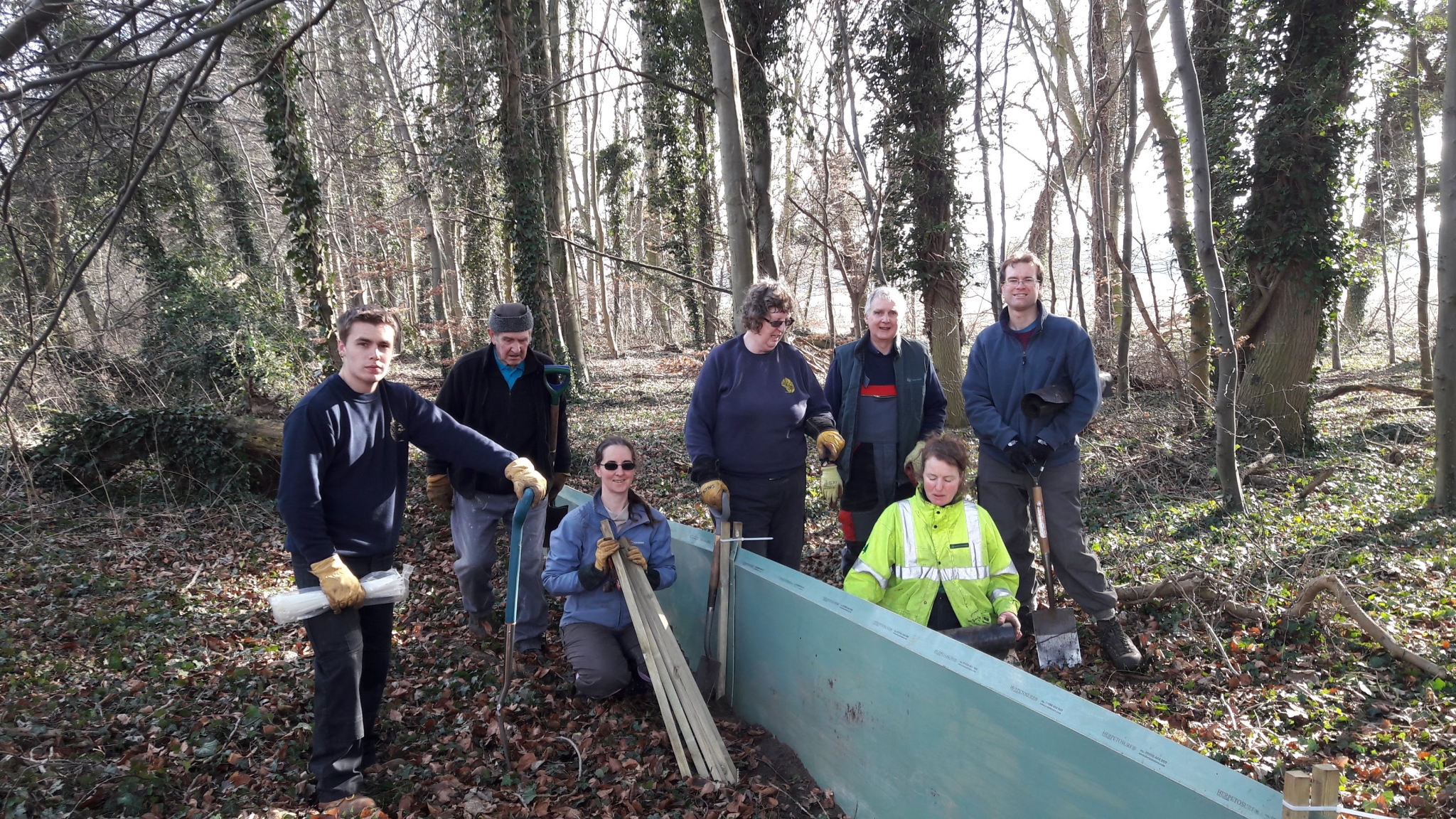 A photo from the FoTF Conservation Event - February 2018 - Erecting the Toad Fence at Cranwich : A group photo of the volunteers by a section of errected fence