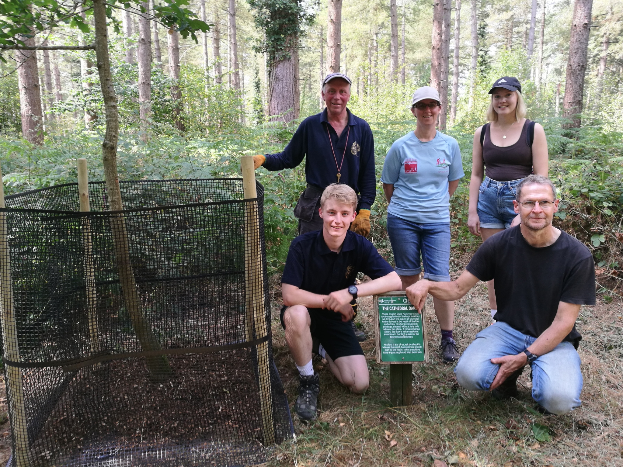 A photo from the FoTF Conservation Event - July 2022 - Oak Tree Cages at Lynford Arboretum : A group photo of the some of the colunteers by one of the Oak trees thet fitted with a tree cage